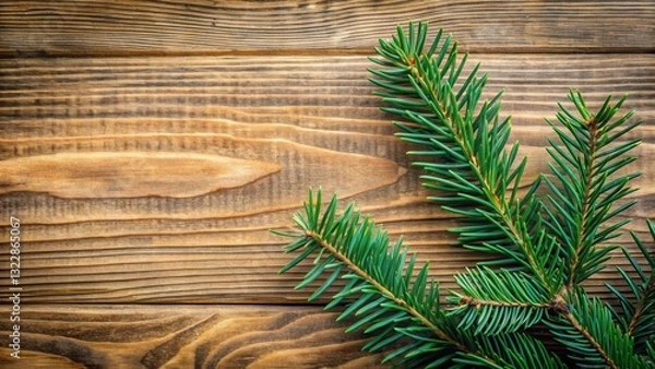 Fototapeta A spruce branch with dark green needles is placed against a wooden background with a natural wood grain texture, wooden background, forest