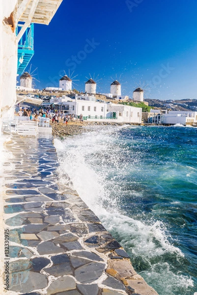 Obraz Splashing waves and famous Mykonos windmills in golden afternoon light, Mykonos island, Cyclades, Greece