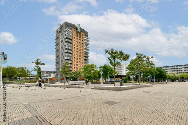 Fototapeta A contemporary building surrounded by greenery and open public spaces, showcasing urban development and planning in a city environment.