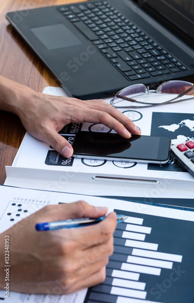 Fototapeta Business workers discussing digital graphs and diagrams indicati