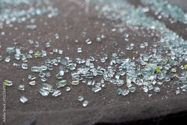 Fototapeta This captivating closeup image beautifully showcases scattered glass shards on a dark surface, emphasizing their stunning reflections along with a mesmerizing array of color variations and textures