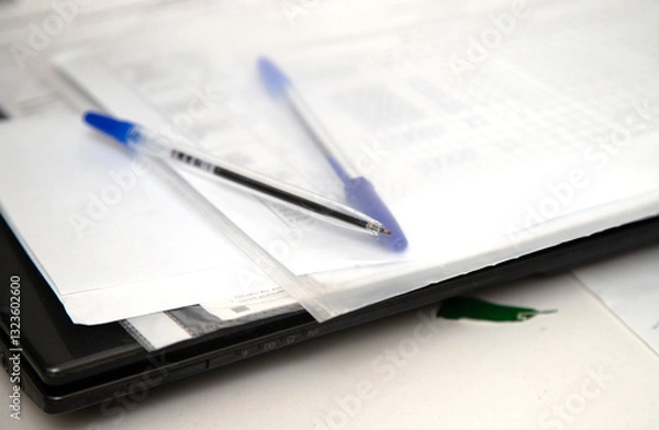 Fototapeta A pen and a blue pen are on top of a piece of paper