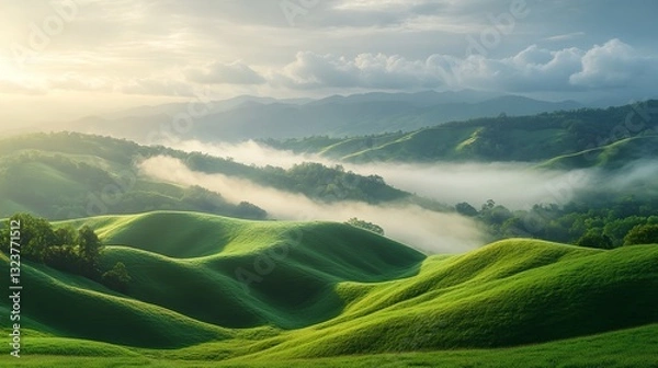 Fototapeta Rolling Green Hills Covered in Mist, Golden Sunlight Breaking Through Clouds