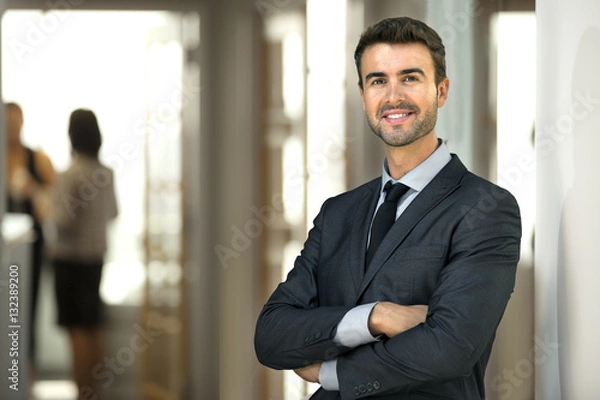 Fototapeta Business man CEO executive at office workplace standing confidently with staff at work