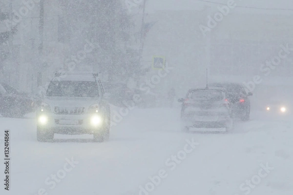 Obraz poor visibility on the road during a snowfall , the movement of vehicles in winter conditions