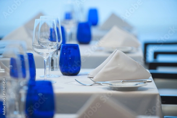 Fototapeta Elegant clean simple white linen restaurant table setting glass silverware china