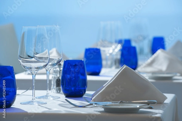 Fototapeta Elegant clean simple white linen restaurant table setting glass silverware china