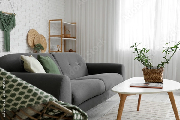 Fototapeta Light interior of modern living room with bamboo stems on coffee table, armchair and sofa