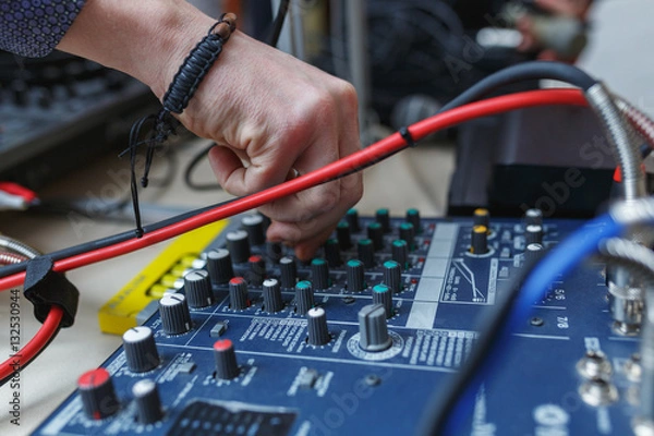 Fototapeta Man sets the audio level on the console audio effects.