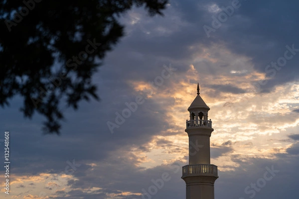 Fototapeta The top of the mosque tower with cloudy sky