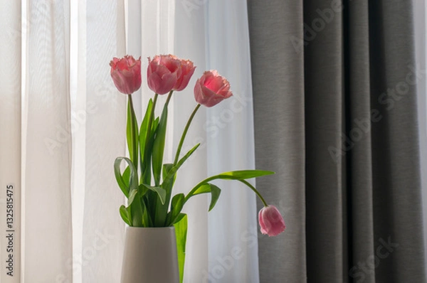 Obraz Pink tulips in white vase on white table by window.