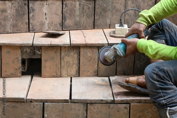 Fototapeta selective focus The grinder in the hands of the technician is using the grinder to polish the wooden board and the wooden stairs to adjust the shape to be beautiful.