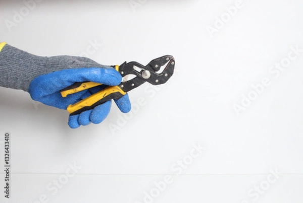 Obraz Universal wrench in the hand in a blue glove