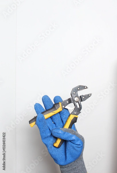 Obraz Universal wrench in the hand in a blue glove