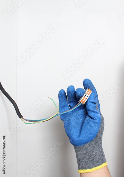 Obraz Wires for wires in a hand in a blue glove