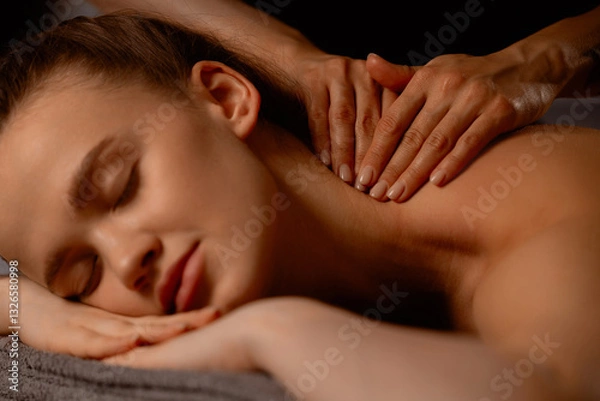 Fototapeta Hands of a massage therapist for young caucasian woman in tranquil spa environment