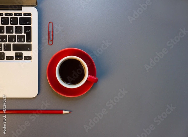 Obraz Desk with laptop, eye glasses, pen, notepad and a cup of coffee. Top view with copy space.