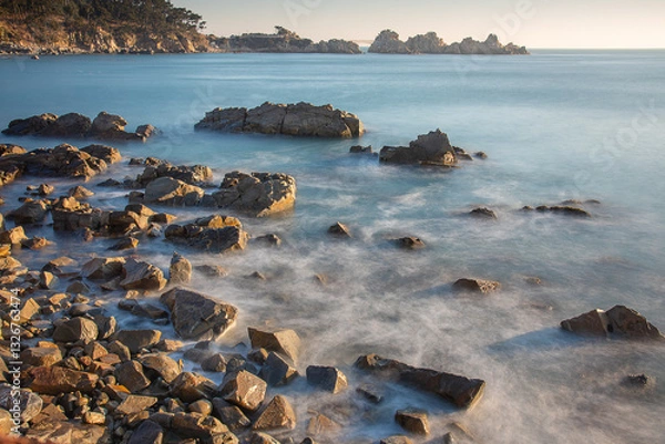 Fototapeta Coast of Korea with round rock formations, a long exposure sea water at sunrise with some vegetation on the shore