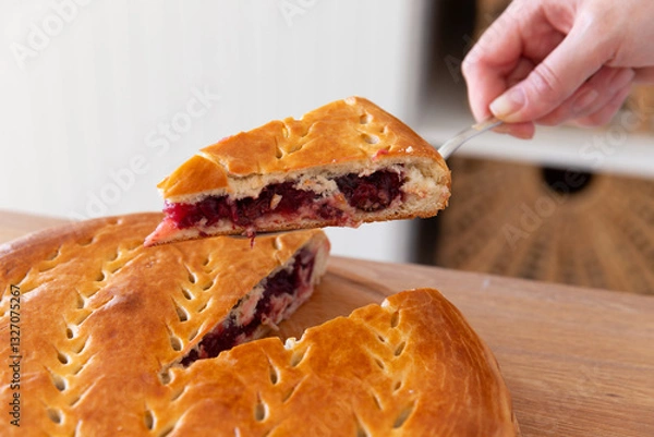Fototapeta Taking a piece of cherry pie with a spatula.