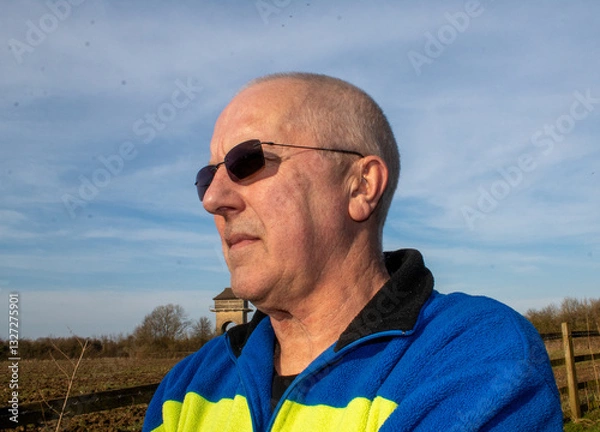 Obraz portrait of an elderly man looks into the distance wearing sunglasses