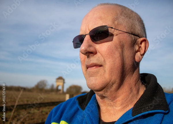 Obraz portrait of an elderly man looks into the distance wearing sunglasses