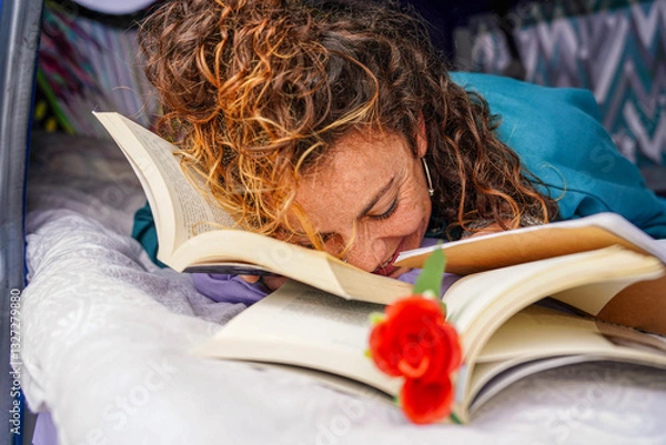 Fototapeta Curly-haired woman with books and a rose on sant Jordi