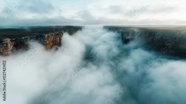 Fototapeta A breathtaking view of a canyon filled with dense clouds, creating an ethereal and serene atmosphere at twilight, enveloping the landscape in a mystical vibe.
