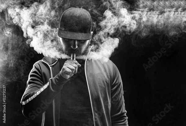 Obraz vaping mężczyzna trzymający mod. Chmura pary. Czarne tło