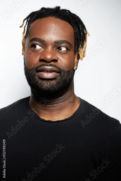 Obraz Portrait of a confident Black man with well-groomed beard wearing a denim shirt against a white background