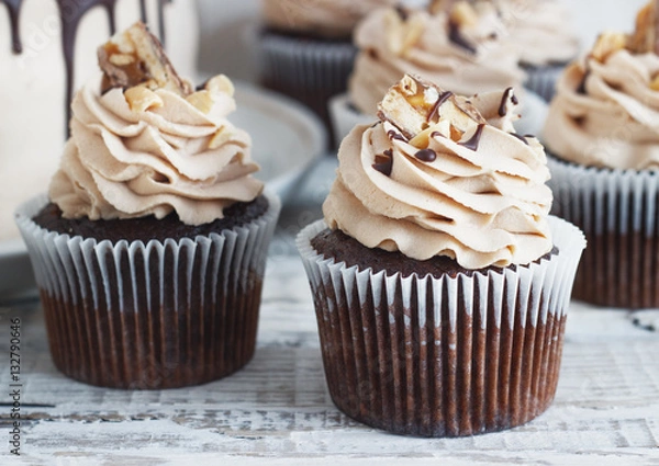 Obraz Chocolate cupcake with mousse cream icing on grunge white wooden background copy space