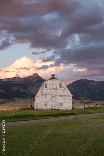 Obraz Rustic Barn in Bozeman, Montana with Vibrant Sunset and Mountain Backdrop