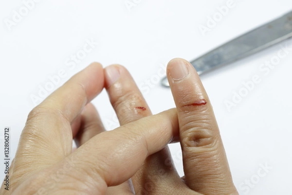 Fototapeta Red blood with cutting wound at the finger of woman hand isolated on white background. Accident from sharp metal concept. First aid and insurance.