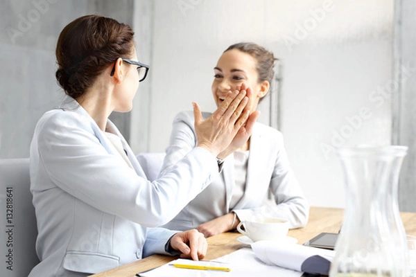 Obraz Sukces w biznesie.wie szczęśliwe kobiety biznesu podają sobie dłoń świętując sukces.