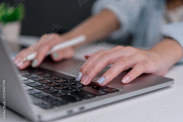 Fototapeta Close-up of a businesswoman typing on a laptop keyboard, representing remote work and digital productivity.
