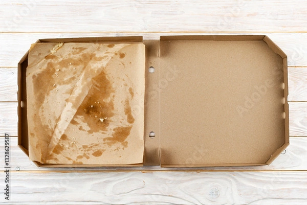 Obraz Empty pizza box with breadcrumbs on white wooden table flat lay view