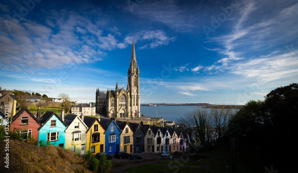 Obraz Cobh, Ireland  - March 6th 2025 - Saint Colmans Cathedral and colourful houses on West View