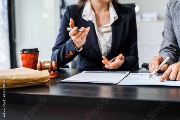 Obraz Two female lawyers in business suits meet at wooden desk, shaking hands over contract paper. wooden gavel and scales justice as discuss legal compliance, corporate law, dispute resolution.