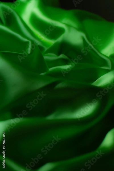 Fototapeta Vibrant green silky fabric with smooth folds and glossy texture. Ideal for luxury fashion, textile design, branding, nature-inspired themes, digital art, and eco-friendly product backgrounds
