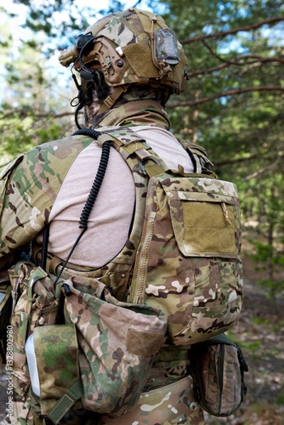 Fototapeta Soldiers in the forest. Military men in camouflage with weapons.