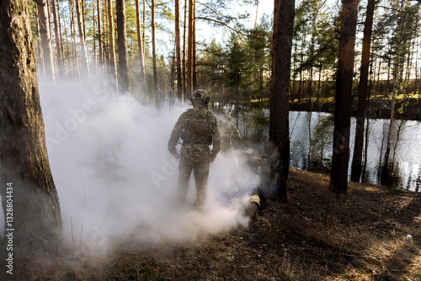 Fototapeta Soldiers in the forest. Military men in camouflage with weapons.