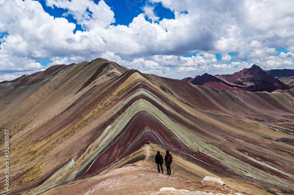 Fototapeta Tourists couple stand and look afar at Rainbow Mountains, Cusco, Peru.