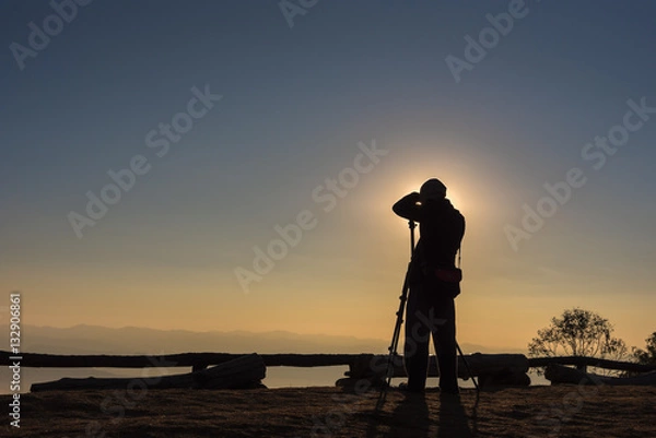 Fototapeta Silhouette of photographer taking photos in the mountains. Filter effect style