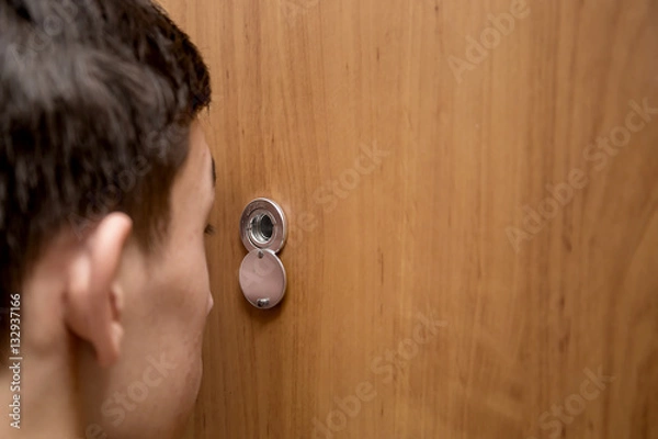 Obraz man looks through the peephole
