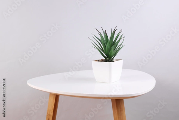 Fototapeta Decorative artificial plant in a pot on a coffee table