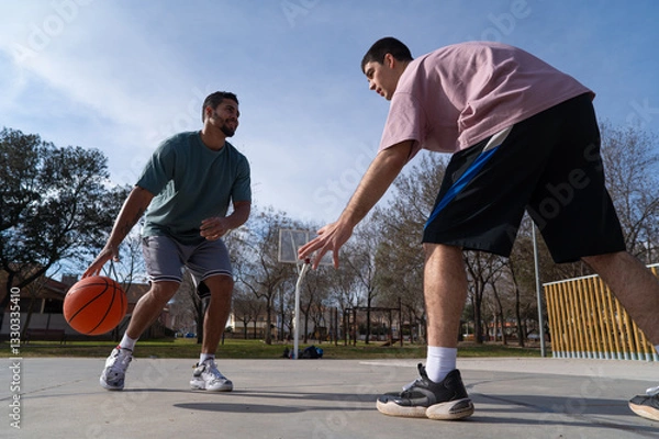 Fototapeta Caucasian and latin friends playing basketball on a sunny day