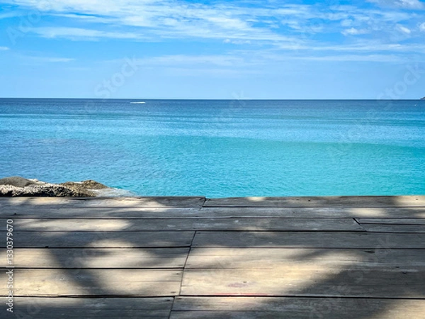 Fototapeta An Empty Wooden Deck with A Serene Ocean View Background