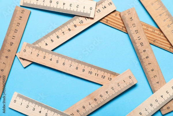 Obraz Wooden rulers on blue background