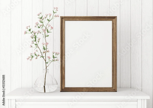 Fototapeta Vertical interior mock up with empty wooden frame and blooming twig on wooden wall background. 3D rendering.