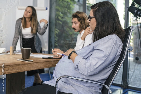 Obraz Young team of coworkers doing a meeting in a modern studio