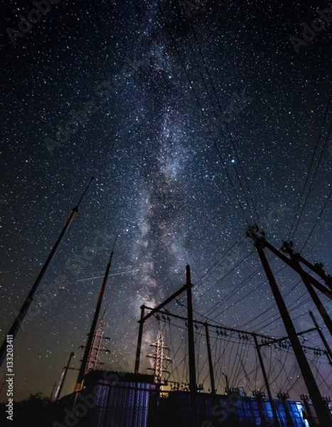 Fototapeta Milky way and starry sky over the power line.